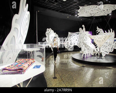 Les visiteurs voir une œuvre d'art avec des motifs décoratifs ethniques au cours d'une exposition au Musée d'Art de Beijing à Beijing, Chine, 7 août 2019. Banque D'Images