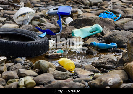 Les déchets en plastique polystyrène et pneu de voiture sur la côte de l'océan. La pollution de l'environnement problème écologique mondial. Banque D'Images