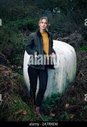 Portrait d'une femme blonde dans une forêt avec la main dans sa poche Banque D'Images