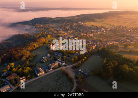 Petite ville village durant le lever du soleil avec la brume. Entouré de collines en Basse-Autriche. Drone photo aérienne Banque D'Images