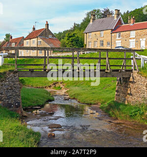Pont de bois sur Hutton Beck dans le village de Hutton-le-Hole sur le bord de la North York Moors dans Yorkshire, Angleterre, Royaume-Uni Banque D'Images
