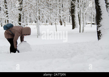 Jeune femme sort un gros bonhomme de neige pour un Banque D'Images