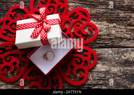 Boîte-cadeau avec une bague de mariage à l'intérieur d'un modèle de coeur rouge Banque D'Images