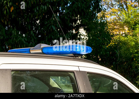 Avertissement sur la barre lumineuse bleue une voiture de police ou d'urgence. Le pinceau lumineux montés sur le toit d'un véhicule blanc. Transport d'urgence la lumière. Close-up. Banque D'Images