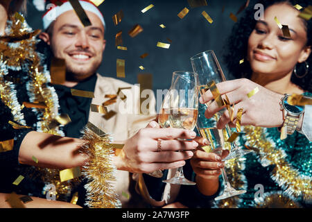 Multiethnic friends toasting with champagne fêter Noël ou Nouvel An, féliciter et profiter de parti. Célébration et Cheers co Banque D'Images