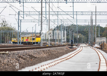Modernisation de la ligne de chemin de fer en Pologne. Nouvelle piste, pierre concassée, traverses, poteaux, poutres, à l'infrastructure énergétique. Banque D'Images