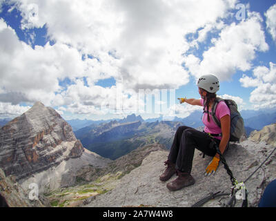 Young attractive brunette femme climber sur un pic de montagne dans les Dolomites se dirigeant à la distance Banque D'Images