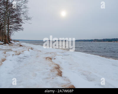 Ligne de côte Lielupe debouchment à mer Baltique après tempête avec des arbres tombés durant le gel de l'hiver avec des tons gris et ciel nuageux Banque D'Images