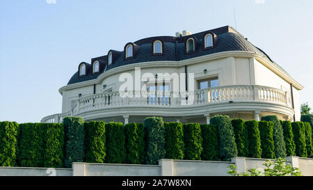 Maison blanche derrière une barrière verte vie Banque D'Images