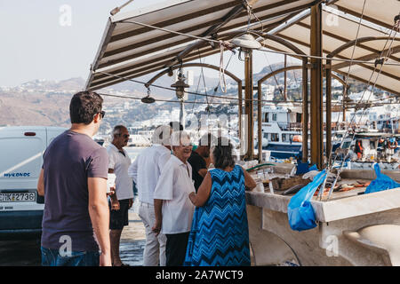 La ville de Mykonos, Grèce - 20 septembre 2019 : Women chatting tout en faisant la queue pour acheter du poisson frais à partir d'un vendeur de rue dans le port de Hora, également connu sous le nom de Pietro Banque D'Images