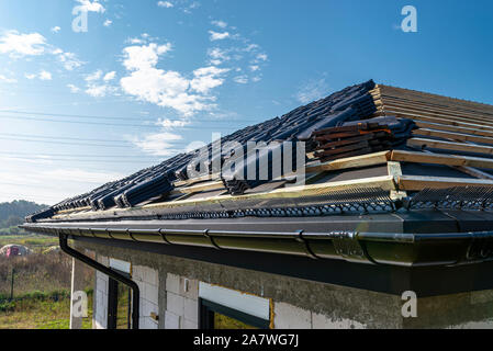 Carreaux de céramique toit disposés en paquets sur le toit du pavillon sur lattes. Préparation pour la pose des tuiles. Banque D'Images
