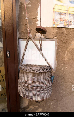 Un panier attaché à une corde qui est utilisé pour être rempli de boutiques et des levées jusqu'à un appartement à Naples, Italie Banque D'Images