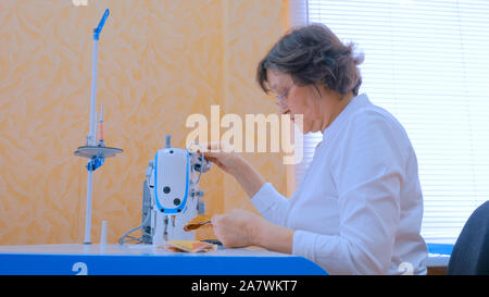 Concepteur de vêtements femme couture avec machine à coudre à l'atelier Banque D'Images