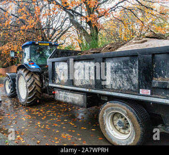 Un tracteur tractant une grande remorque chargé avec le sol. Banque D'Images