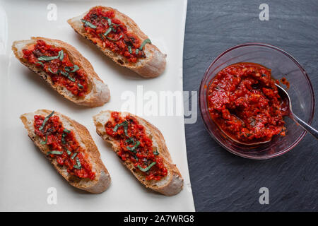 Assiette de Bruschetta Tomate-poivre et basilic frais sur ardoise noire Banque D'Images