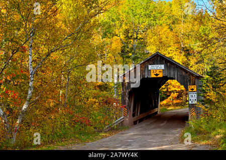 Un paysage d'automne image de l'emblématique pont couvert Trout Creek sur une route rurale en gravier près de Sussex au Nouveau-Brunswick, Canada. Banque D'Images