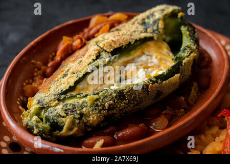 Chilles et chile rellenos accompagné de riz mexicain traditionnel servi dans les plaques d'argile Banque D'Images