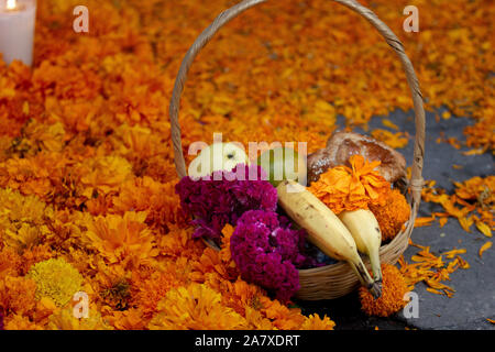 Un mexicain fait main panier avec bananes, oranges, fleurs jaunes, apple et pan de muerto, pain sur un tapis avec des fleurs de souci, de l'espace pour le texte Banque D'Images