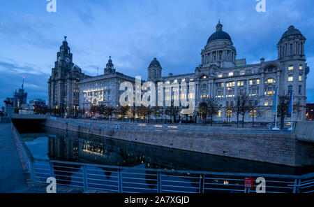 Les bâtiments des Trois Grâces, Royal Liver Building, Cunard Building et Port of Liverpool Building, vu la nuit à Pier Head à Liverpool Banque D'Images