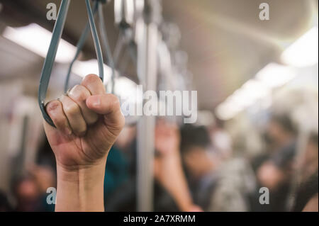 Jeune femme passager main tenant la poignée sur le train ou l'autobus pour la sécurité. Sécurité voyage, Banque D'Images