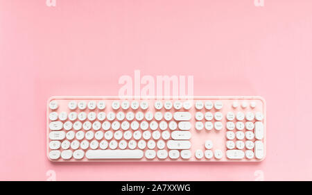 Clavier ordinateur rose avec boutons blancs isolés contre fond rose, copy space Banque D'Images