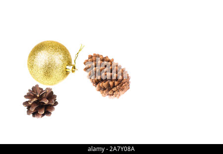 Noël ou Nouvel An arrière-plan. Cônes de pins et d'épinettes et de jouet de Noël boule brillante jaune sur un fond blanc. Copier l'espace. Banque D'Images
