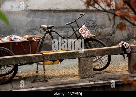 Vieux tricycle rouillé garé au bord de la rivière, dans la vieille ville de Suzhou, Province de Jiangsu, de la République populaire de Chine Banque D'Images