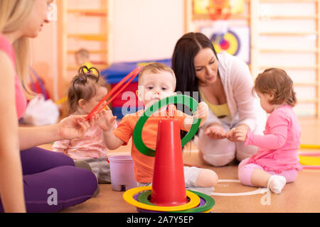 Enfants faire des activités physiques avec l'enseignante de la maternelle ou crèche Banque D'Images