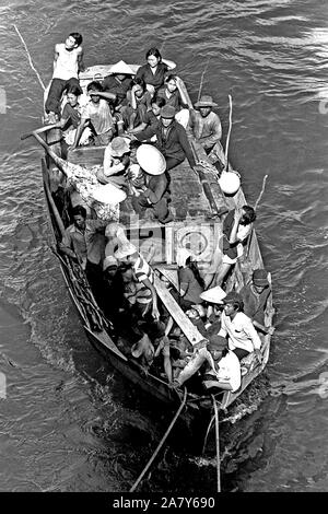 Un bateau transportant 35 réfugiés vietnamiens vient le long de la commande amphibie USS Blue Ridge (LCC-19). Les réfugiés ont été secourus 350 milles au nord-est de la baie de Cam Ranh, au Vietnam, après avoir passé huit jours en mer dans un bateau de pêche de 35 pieds. Banque D'Images