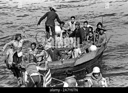 Une ligne est fixée sur un bateau de pêche de 35 pieds par l'USS Blue Ridge (CAC 19) dans la vie de l'équipage d'un bateau. Le navire de commandement amphibie a secouru 35 réfugiés vietnamiens 350 milles au nord-est de la baie de Cam Ranh, Vietnam, après qu'ils avaient passer huit jours en mer. Banque D'Images