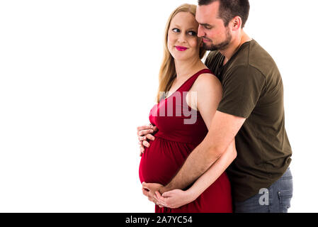 Young pregnant couple dans l'amour, l'enfant attendait studio portrait. Mari est serrant sa femme enceinte dans une relation intime, à son être enceinte Banque D'Images