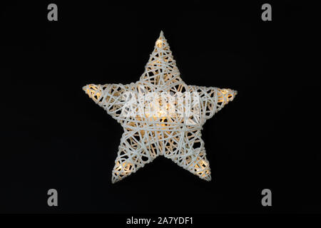 Pretty white star avec ampoules isolé sur fond noir. Décoration de Noël Banque D'Images