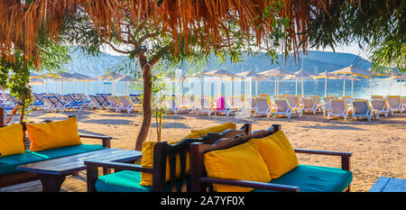 Belle plage sur les rives de la baie bleu calme de la mer au coucher du soleil. Maison de vacances de plage et concept de destination. Bitez, Bodrum, Turquie Banque D'Images