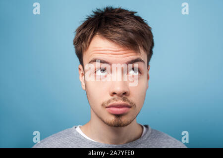 Qu'est avec mes cheveux. Closeup portrait of young brunette homme avec barbe et moustache en petit pull décontracté à enquêter avec regard, dissatisfi Banque D'Images