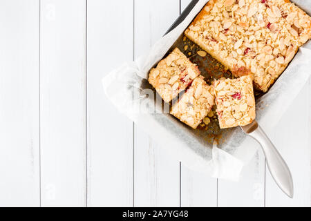 Couper la rhubarbe en partie composé de gâteaux dans une plaque de cuisson sur panneau blanc arrière-plan avec copie espace. Vue d'en haut. Banque D'Images