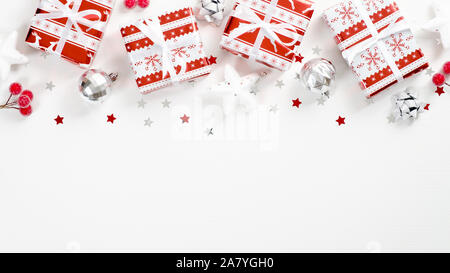 Vacances de Noël présente sur fond blanc avec des décorations rouge et argent. Xmas frame haut faits de boîtes-cadeaux, des étoiles, berry, confetti, ba Banque D'Images