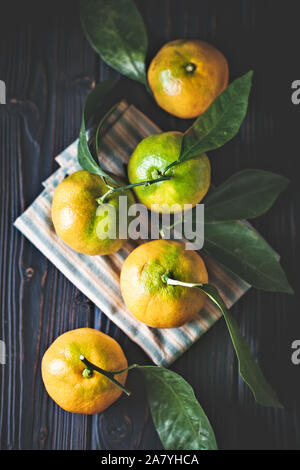 Mandarine avec des feuilles sur un pays à l'ancienne table. Focus sélectif. La verticale. Banque D'Images