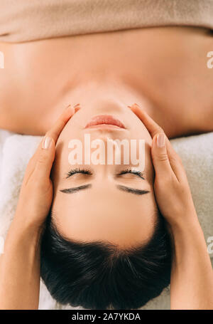 Woman enjoying massage de la tête, face close-up. Relaxing massage anti-stress, tête de traitement de la douleur Banque D'Images