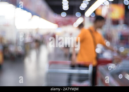 Résumé de l'allée de supermarché floue avec des étagères et méconnaissable les clients comme arrière-plan. Banque D'Images