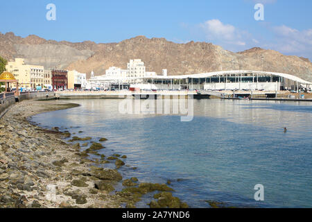 Bord de mer de la ville de Mascate, Oman, avec des bâtiments à l'avant-plan et entouré de montagnes derrière. Banque D'Images