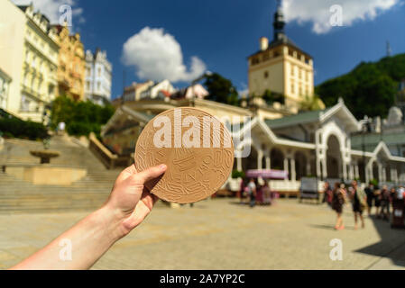 Karlovy Vary, République Tchèque - 2 juillet 2019 : la main avec station thermale traditionnelle gaufre de Karlovy Vary - Karlovy Vary Oblaten, oplatky Banque D'Images