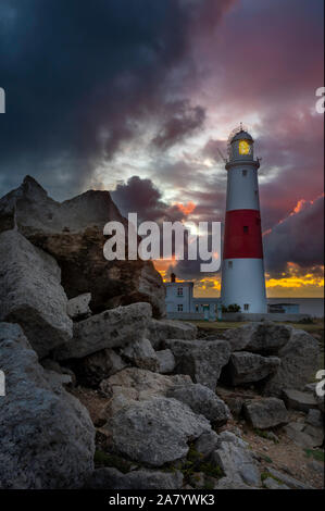 Ciel orageux au lever du soleil à Portland Bill, montrant le célèbre ighthouse Banque D'Images