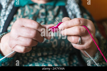 Vieille Femme en tricot accueil près de la fenêtre. Selective focus Banque D'Images