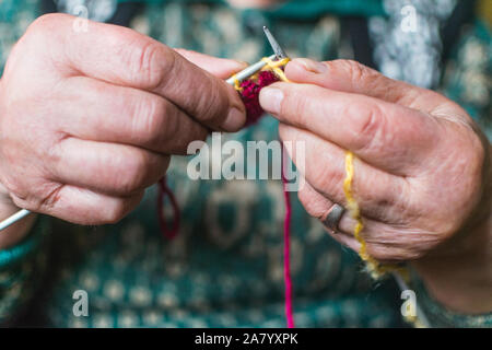 Vieille Femme en tricot accueil près de la fenêtre. Selective focus Banque D'Images