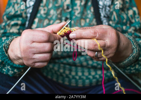 Vieille Femme en tricot accueil près de la fenêtre. Selective focus Banque D'Images