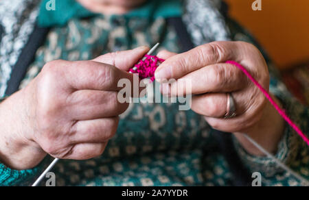 Vieille Femme en tricot accueil près de la fenêtre. Selective focus Banque D'Images