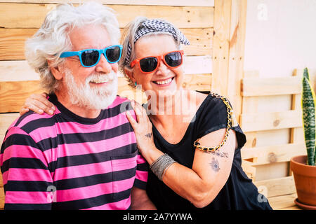 Vieux couple senior jeune alternative avec des cheveux blancs bénéficiant ensemble hugging and smiling in outdoor activité de loisirs - et à la mode look couleur fo Banque D'Images