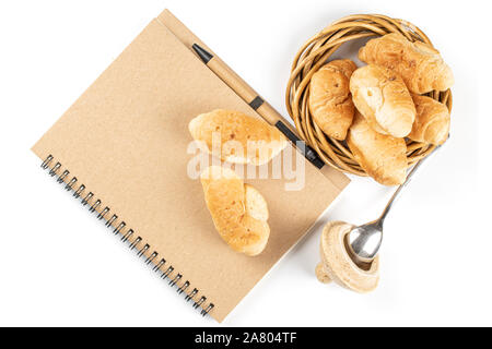 Mini croissant ensemble petit déjeuner avec flatlay carnet et un stylo isolé sur fond blanc Banque D'Images