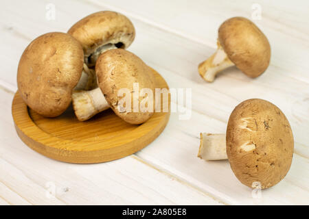 Groupe de cinq entiers et frais, champignon brun sur les montagnes russes en bois de bambou sur fond blanc Banque D'Images