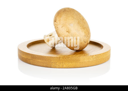 Un champignon brun frais entier sur coaster bambou isolé sur fond blanc Banque D'Images